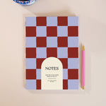 Blue Berry A5 notebook with wavy checkerboard cover in berry red and periwinkle, lined pages, playful retro design.