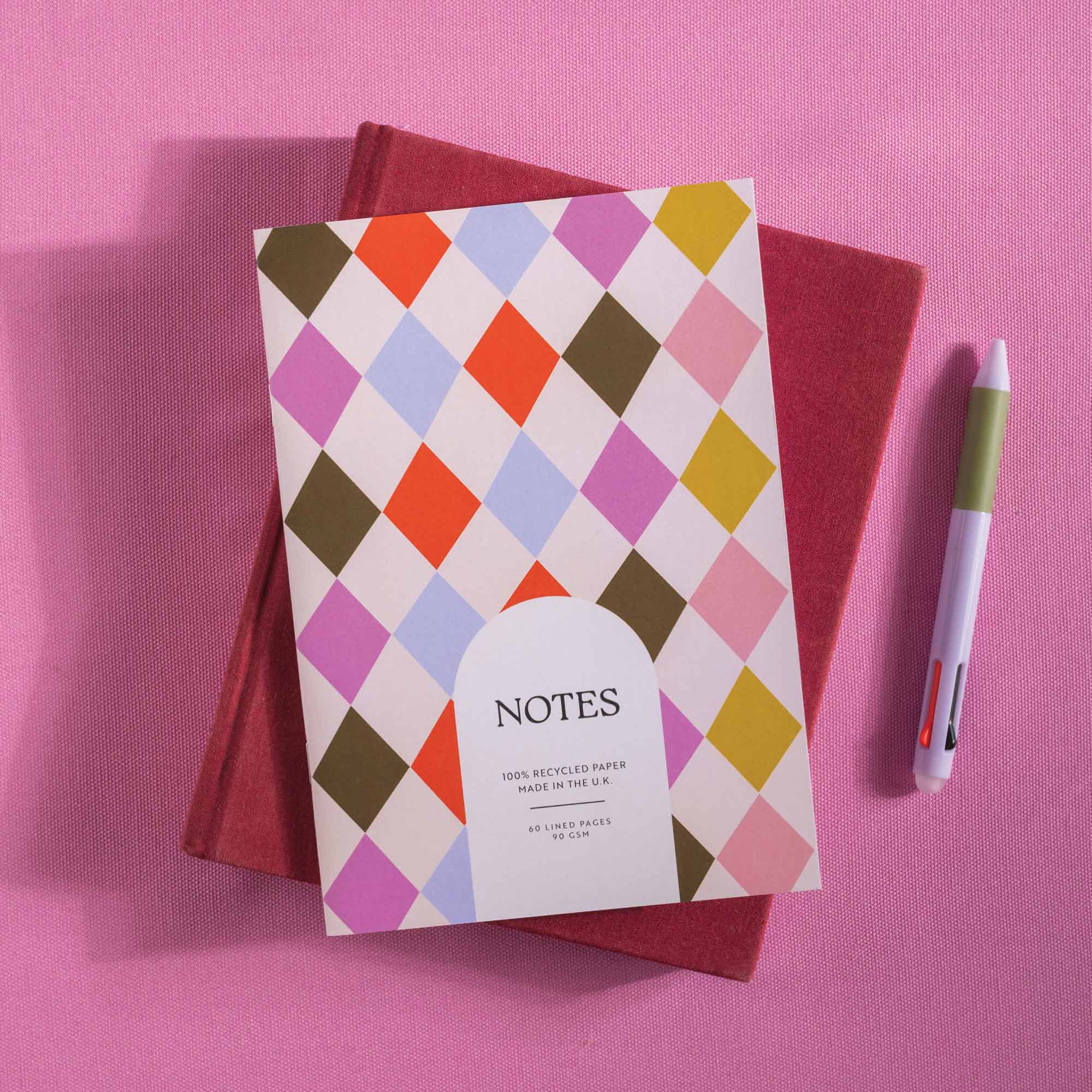 Colorful diamond patterned notebook with 'NOTES' text on a pink background
