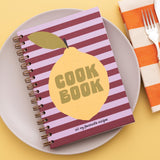 Cookbook with lemon design on a plate with a fork and striped napkin