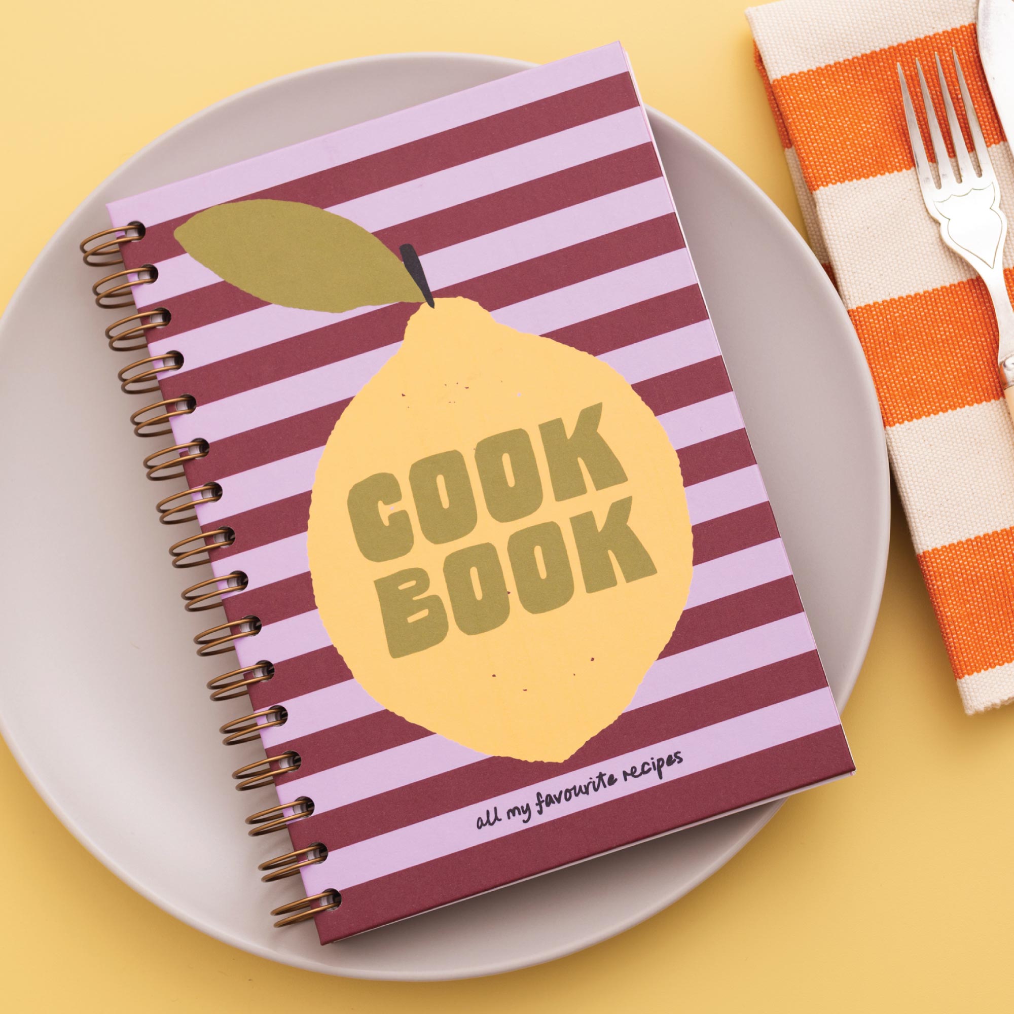 Cookbook with lemon design on a plate with a fork and striped napkin