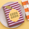 Cookbook with lemon design on a plate with a fork and striped napkin