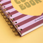 Spiral-bound notebook with striped cover on a yellow background