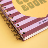 Spiral-bound notebook with striped cover on a yellow background
