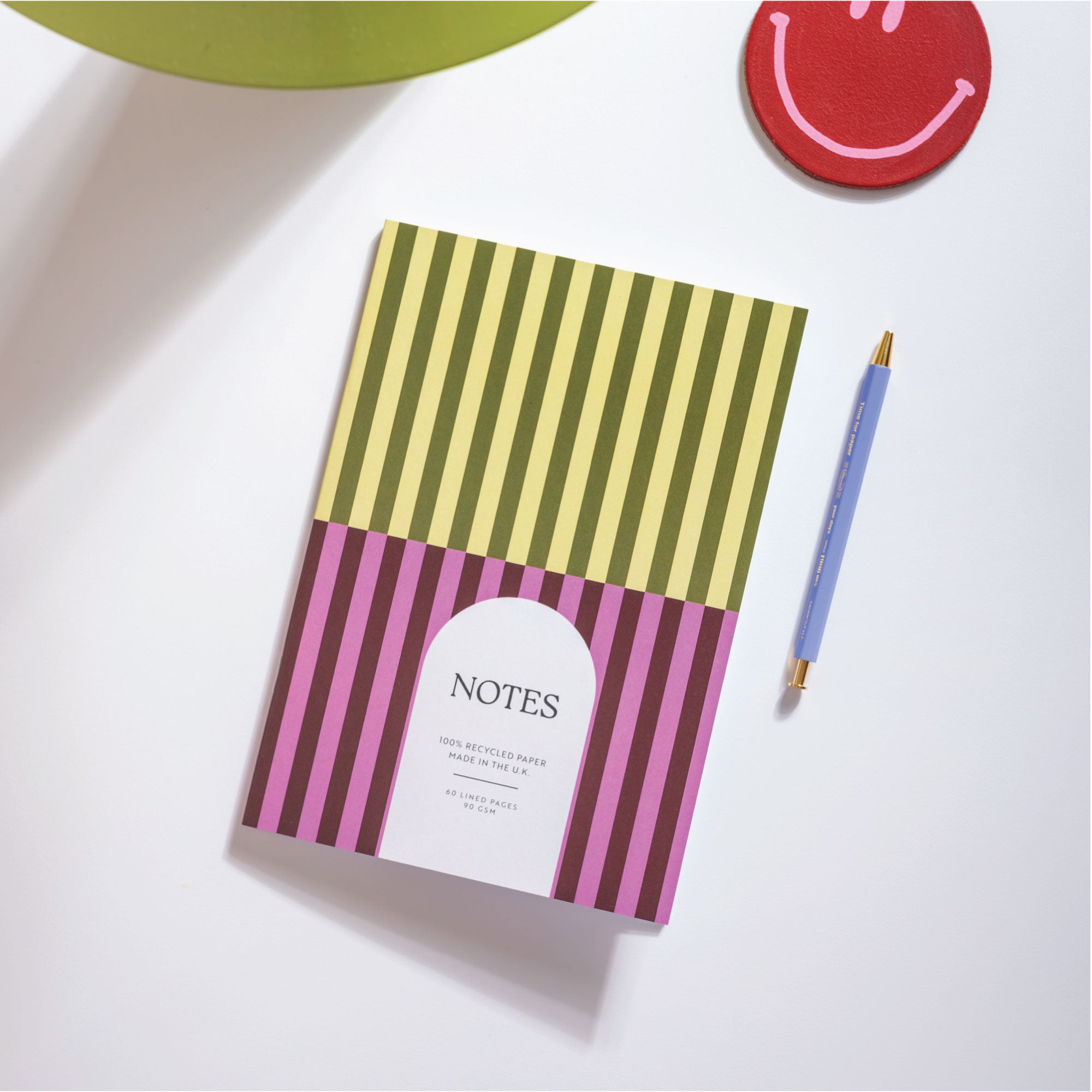 Striped notebook with a pen on a white surface