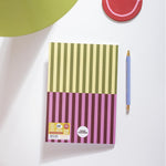 Notebook with striped design on a white surface with a pen next to it
