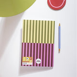 Notebook with striped design on a white surface with a pen next to it