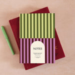 Lined 60 page notebook with pistachio green and plum purple stripe design.