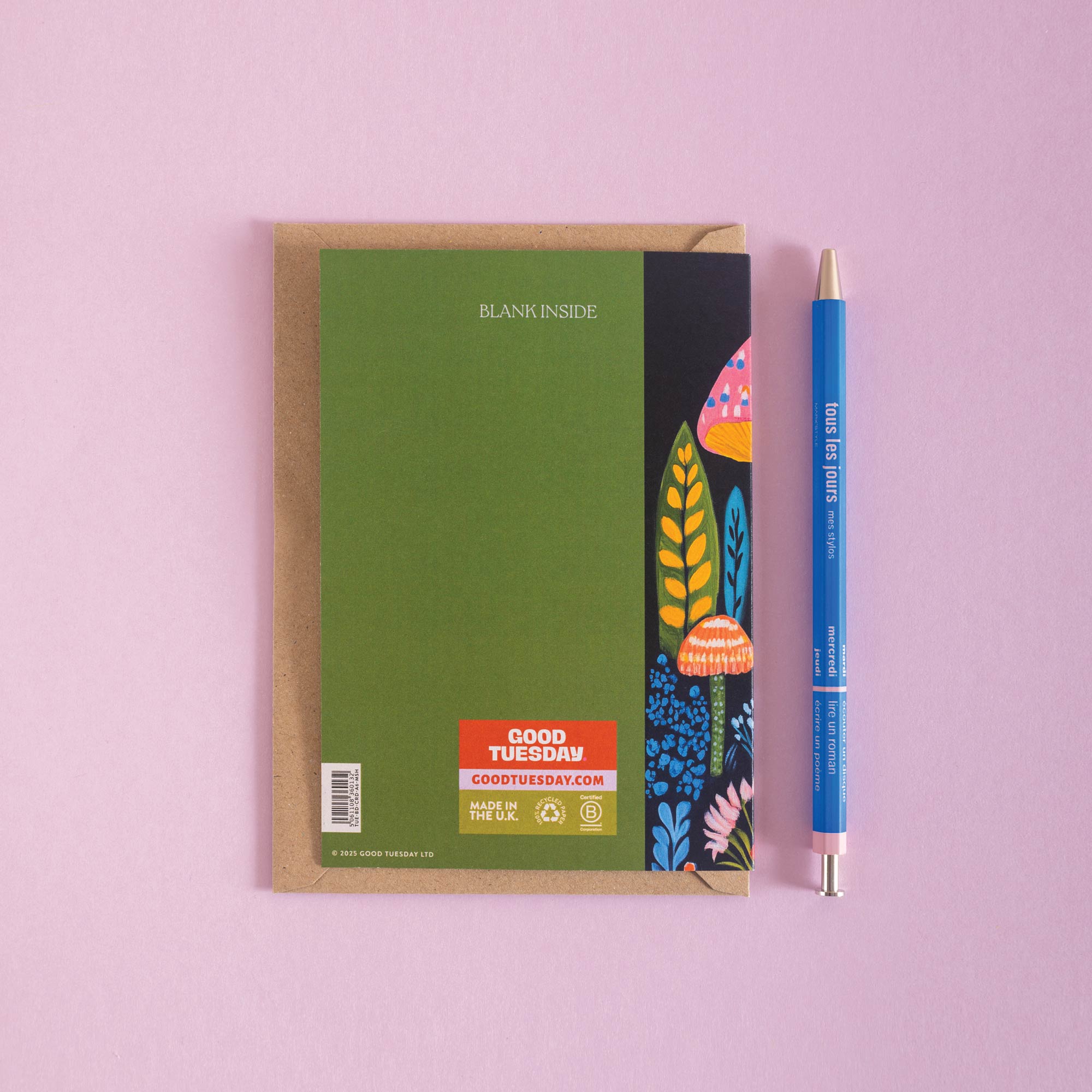 Birthday card with a colorful mushroom design on the cover and a blue pen on a pink background