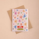 Greeting card with colorful star patterns and a brown envelope on a beige background