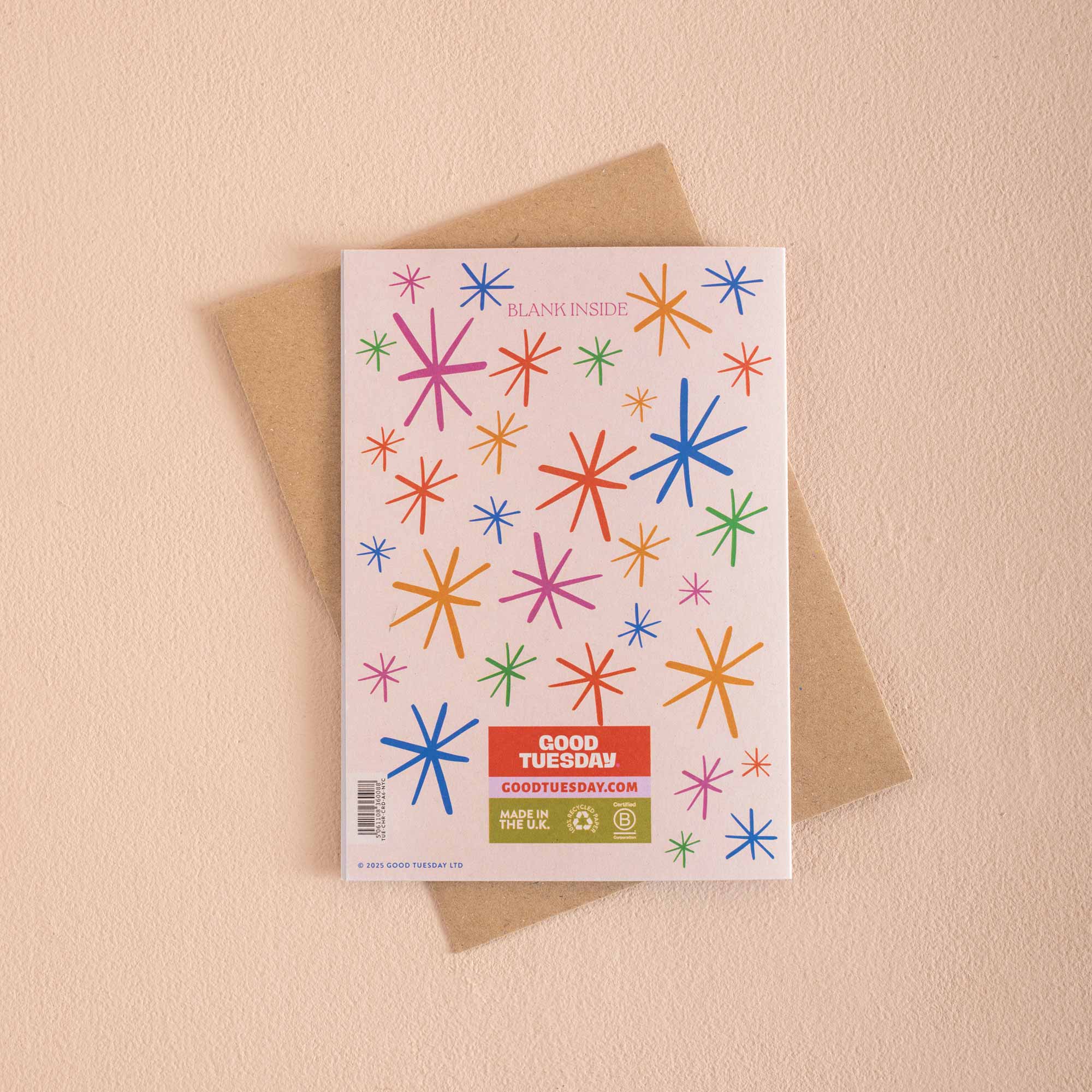 Greeting card with colorful star patterns and a brown envelope on a beige background