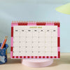 Desk calendar on wooden table, styled with stationery 