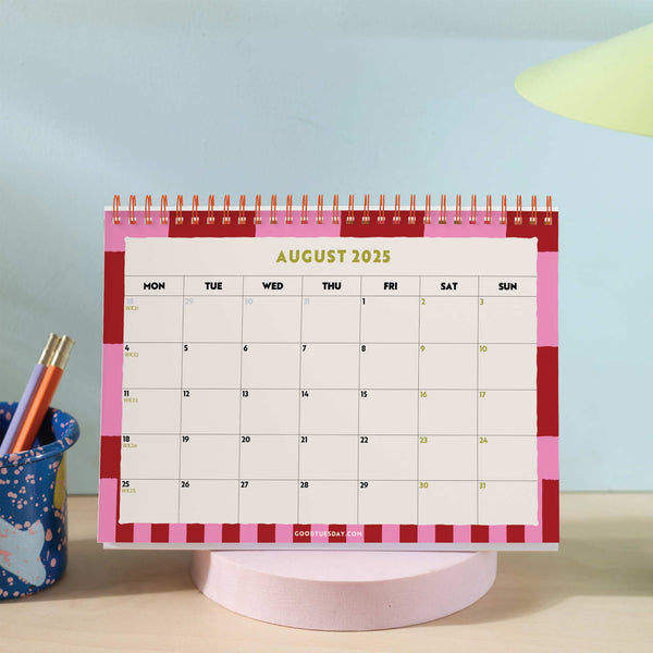 Desk calendar on wooden table, styled with stationery 