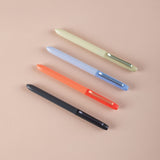 Four colorful pens (black, orange, blue, and green) on a beige background
