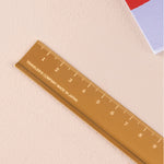 Brass ruler with 'Traveler's Company Made in Japan' text on a beige background