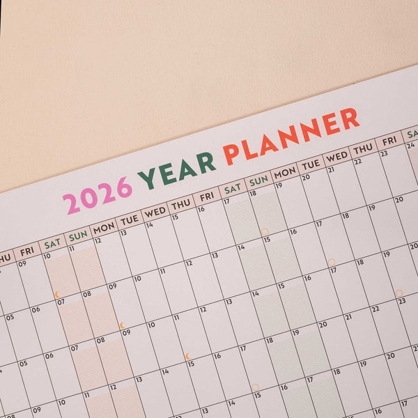 close up of 2026 wall planner showing highlighted weekends and moon phases